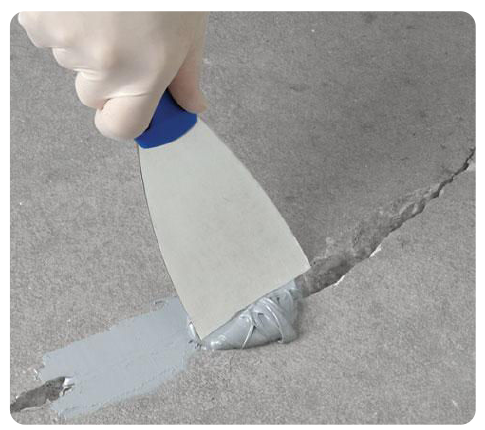 Close-up of concrete crack repair using professional caulking to prevent water infiltration and freeze-thaw damage in Columbus.